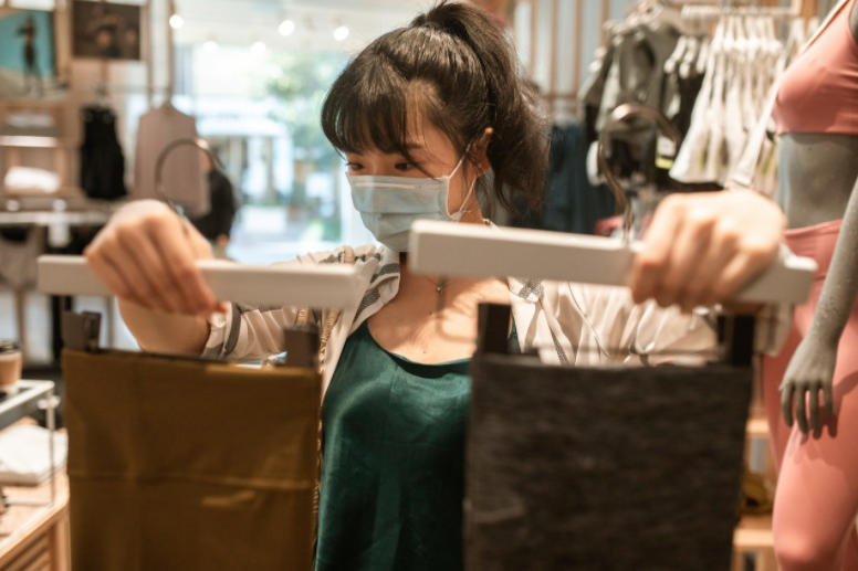 female with mask comparing clothes