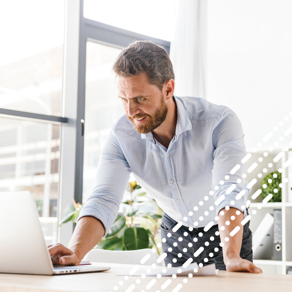 male stood up looking at laptop