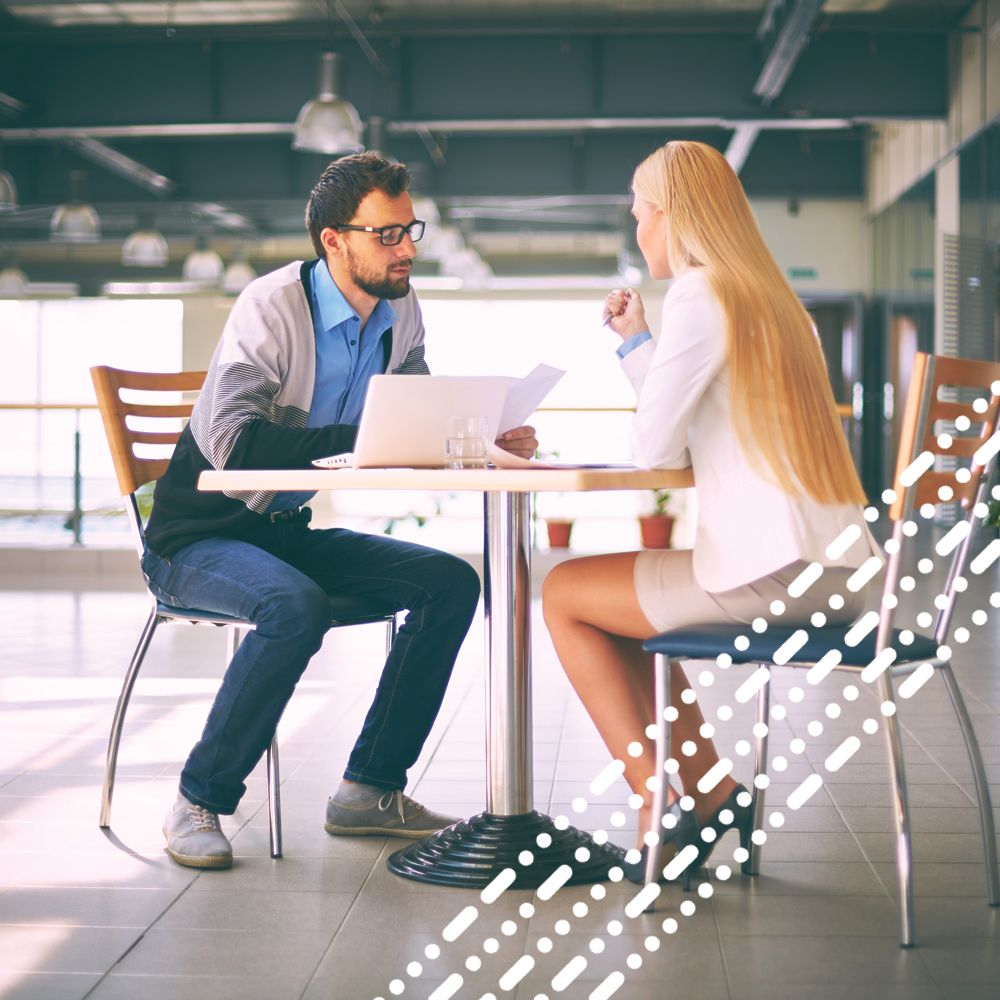 male and female chatting business plans at table