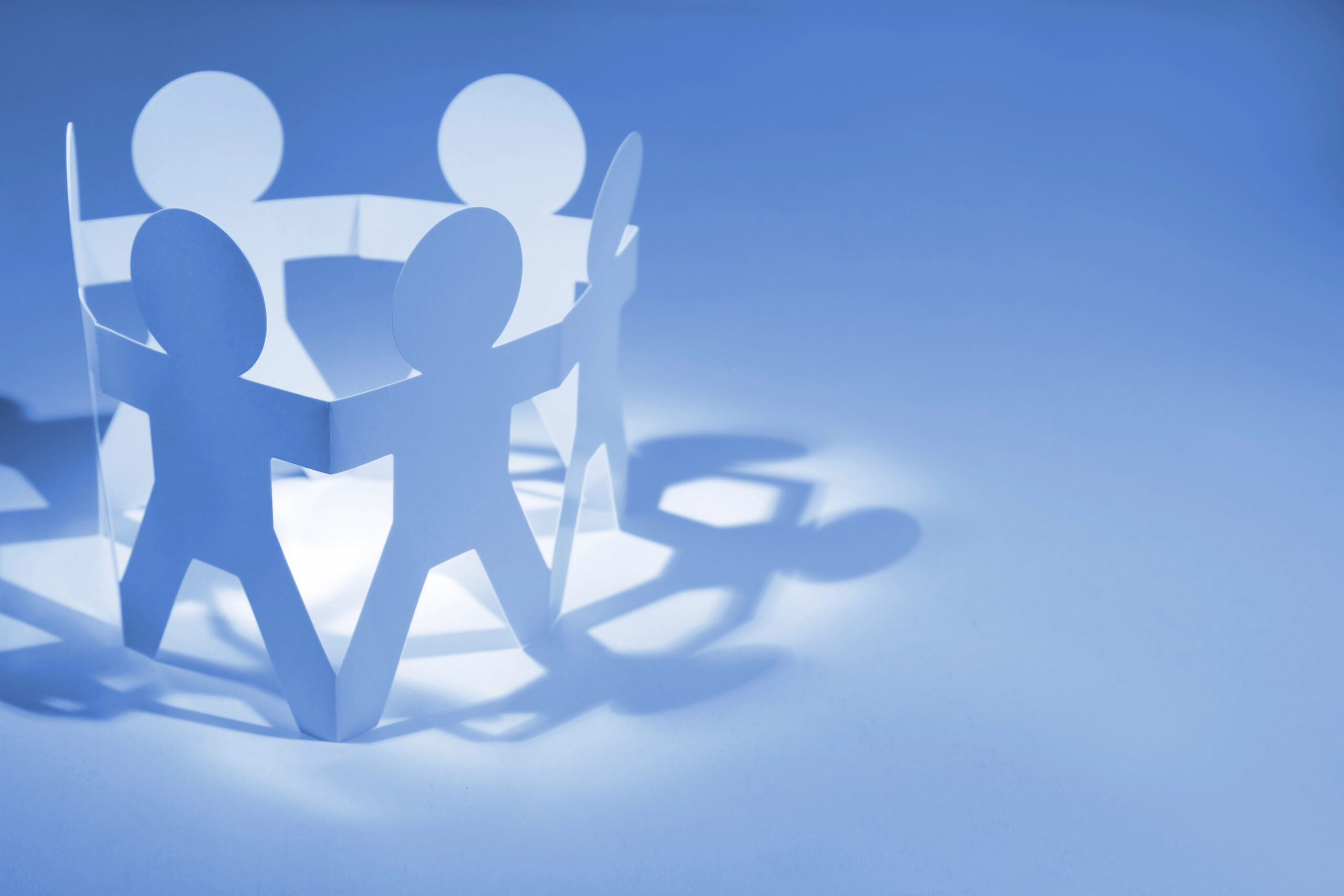 Vertical IQ and Abrigo Partnership - Paper cutout of stick figure people holding hands in a cirlce
