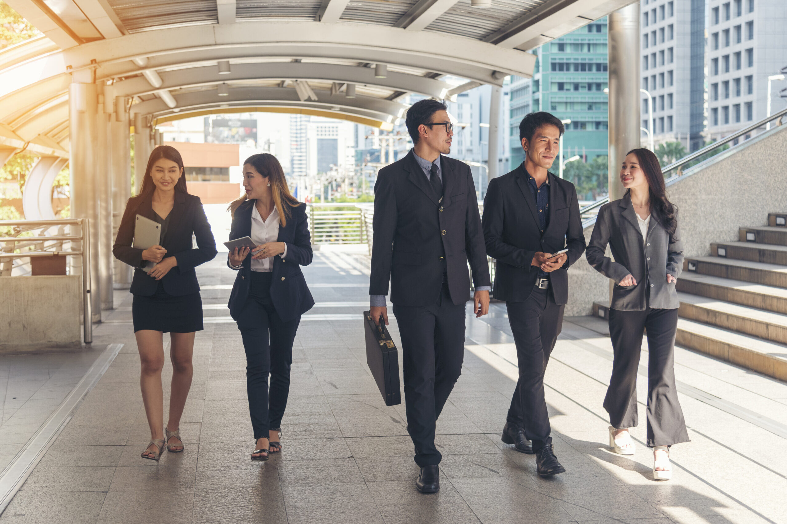 Group of five co-workers walking to work