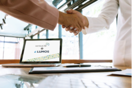 Business partners shaking hands in front of a computer